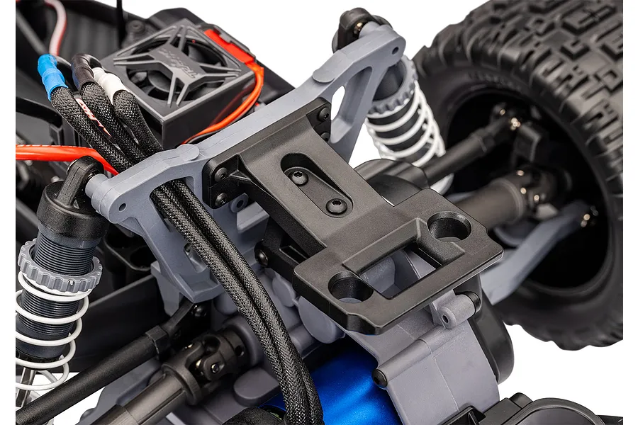 Close-up of the rear suspension and chassis components of a Traxxas RC stadium truck, showing the shock tower, motor, and transmission housing.