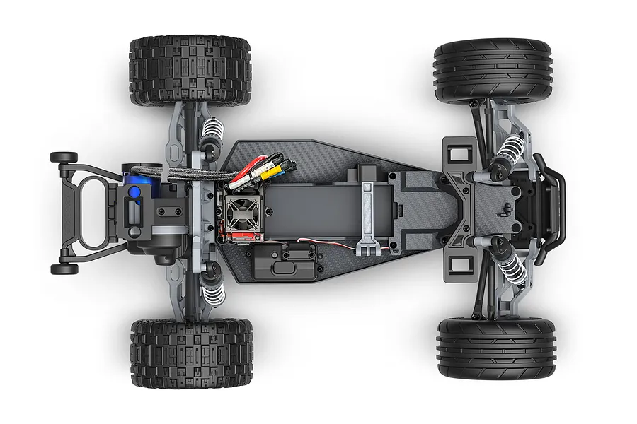 Top-down view of a Traxxas Rustler RC stadium truck chassis showing the motor, electronics, suspension, and tires on a white background.