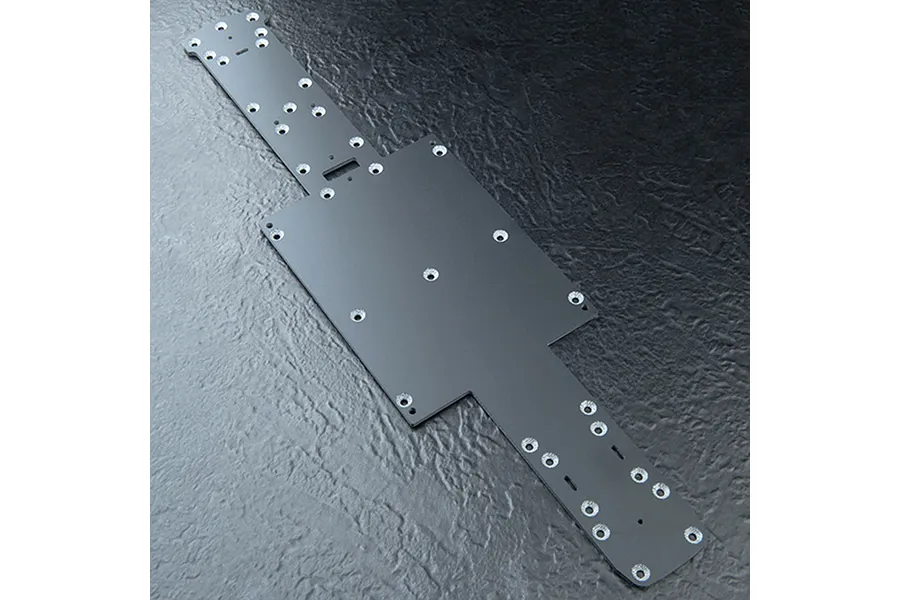 A black FRP main chassis plate for an MST RC car, featuring multiple pre-drilled mounting holes and a flat, rectangular central section.