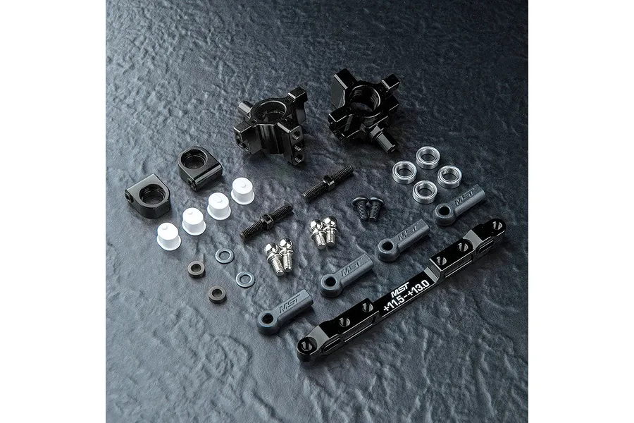 A set of MST black aluminium rear hubs and associated hardware including ball ends, turnbuckles, and spacers on a textured black surface.