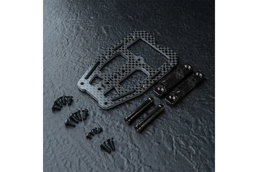 MST carbon fiber front suspension arm mount set including a carbon plate, two metal blocks, two posts, and various black screws on a dark textured surface.