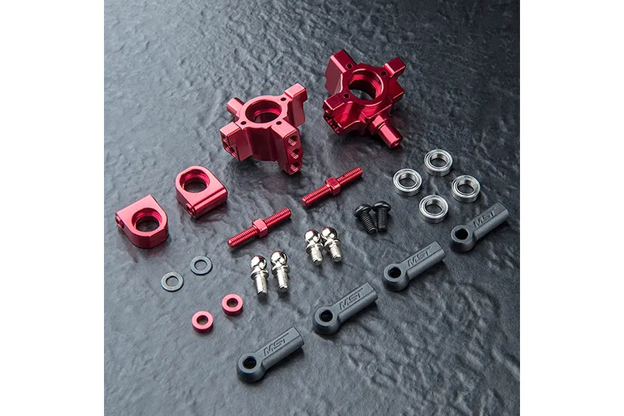 MST aluminium rear hub set in red, including metal hubs, ball ends, turnbuckles, bearings, and screws on a dark textured surface.