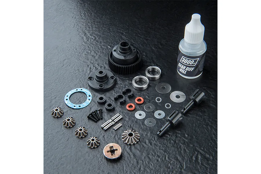 An MST 60T limited slip differential kit including gears, housing, bearings, screws, shims, and a bottle of 3000# gear diff oil on a black surface.