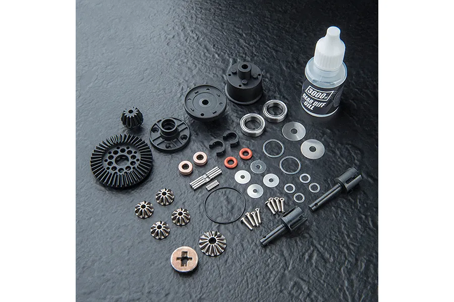 MST Limited Slip Differential gear set components including gears, bearings, shims, screws, and a bottle of 3000# gear diff oil on a black textured surface.