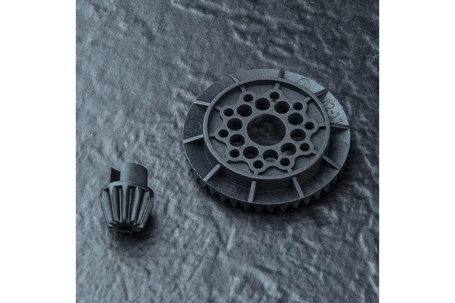 A black plastic 42T differential gear and an 11T pinion gear from MST, set against a dark, textured background.