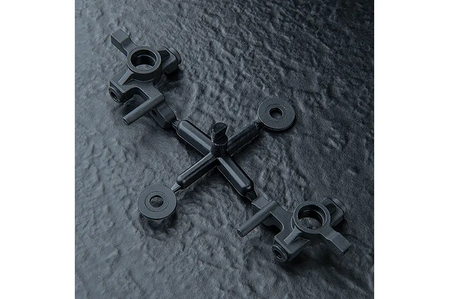 A pair of black plastic MST ATK V3 front hub carriers still attached to their original injection molding sprue tree.