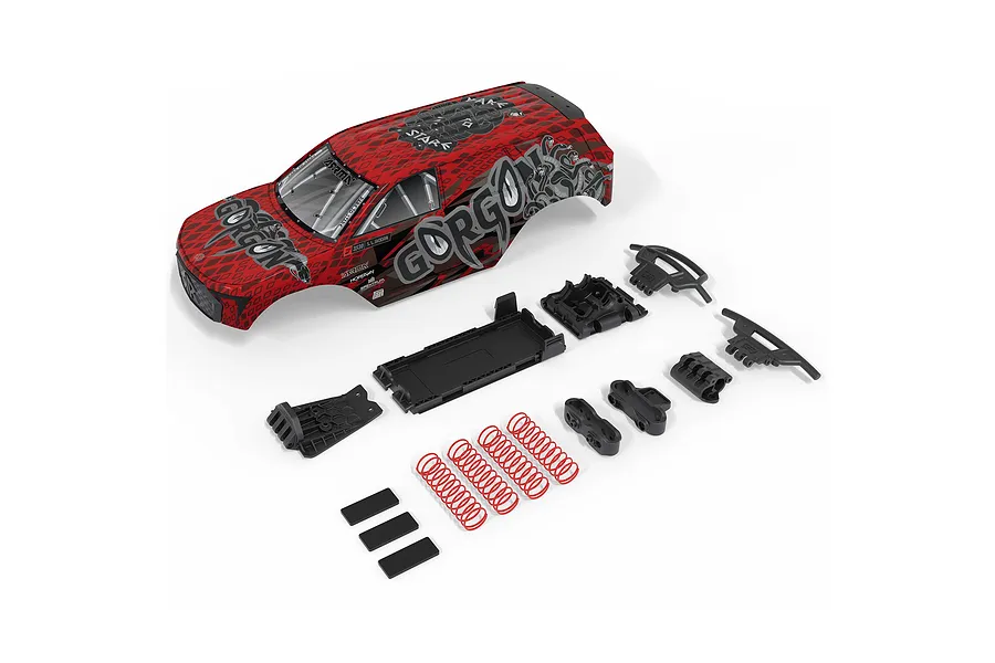 ARRMA Gorgon 1/10 scale RC truck body shell in red and black with included plastic accessories and red coil springs on a white background.