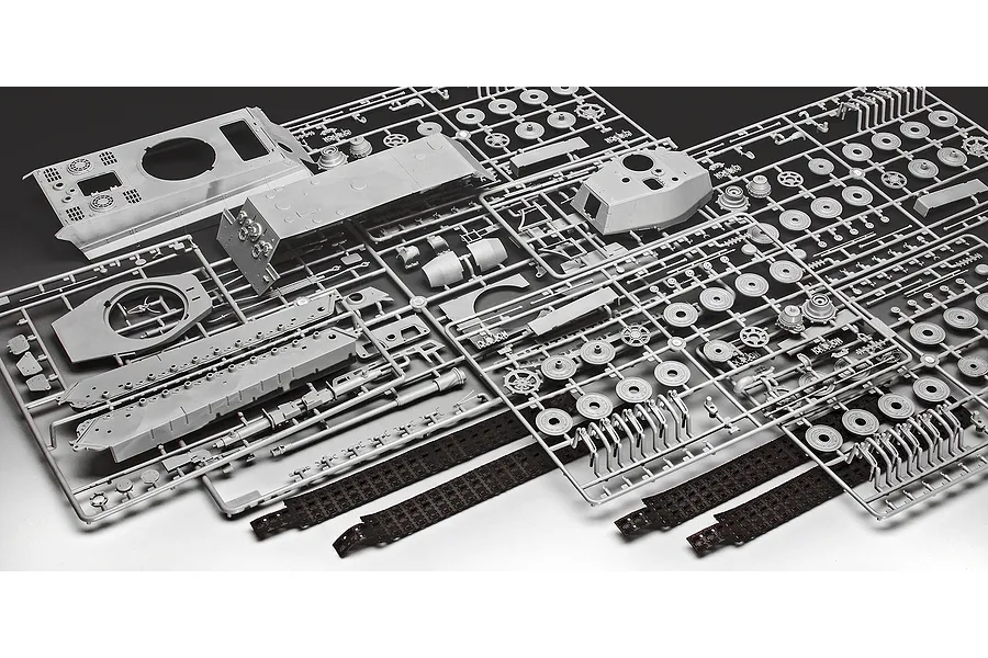 Grey plastic model kit sprues for a Tiger II tank, including hull, turret, and track parts on a white background.