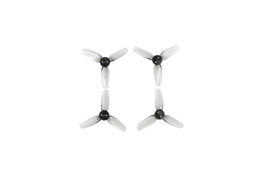 Four clear three-blade propellers for FPV drones arranged in a square pattern against a black background.