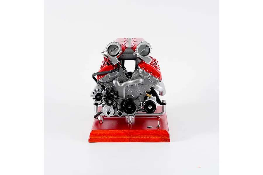 Front view of the Teching DM108 V12 engine model kit mounted on a wooden display base against a white background.