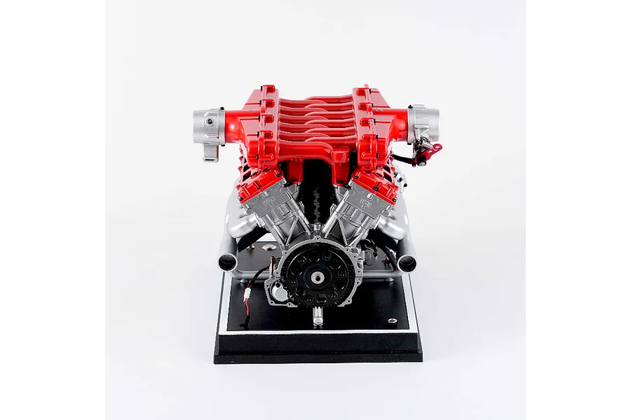 Front view of the Teching DM109 V12 engine model kit featuring red intake manifolds and silver engine block components mounted on a black display base.