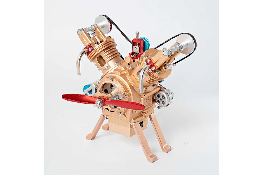 A gold-coloured Teching M114 V2 engine model kit with a red propeller, standing on a white background.
