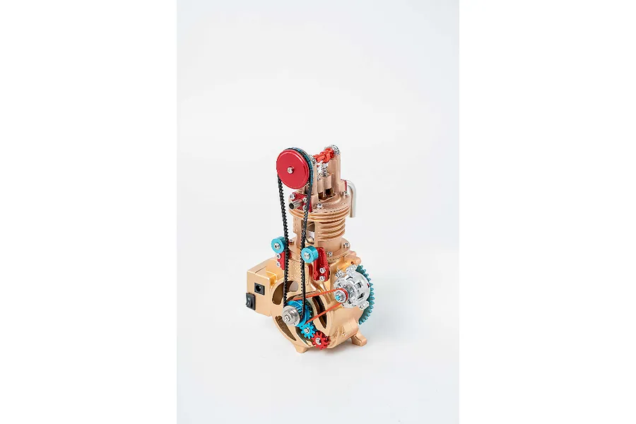 A Teching DM117 single cylinder engine metal model kit featuring gold, red, and blue components with a black timing belt on a white background.