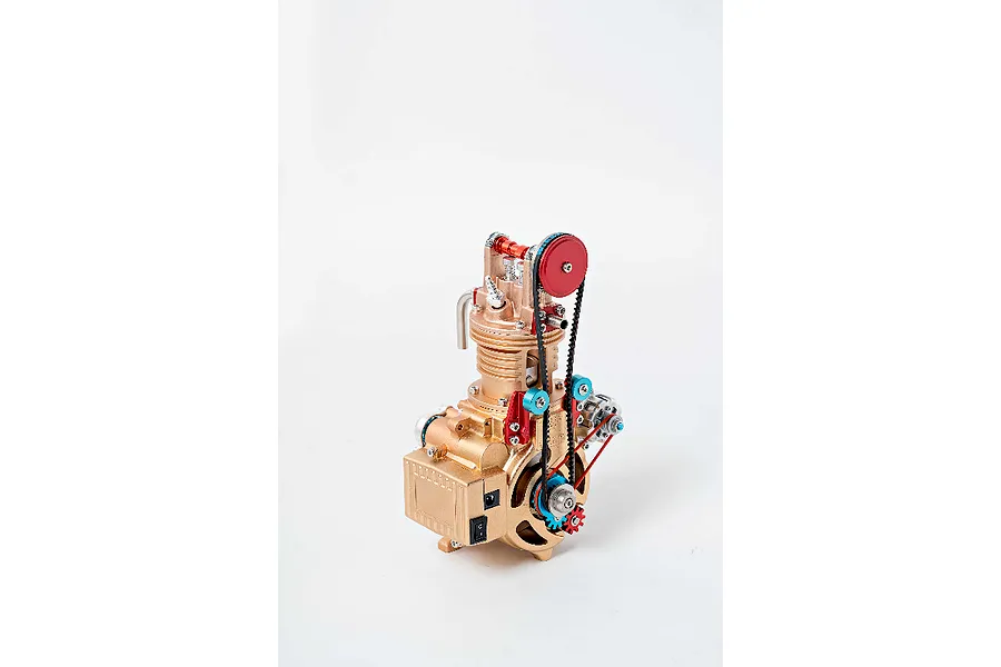 A gold-coloured Teching DM117 single cylinder engine model kit featuring red and blue accents, belts, and gears against a plain white background.