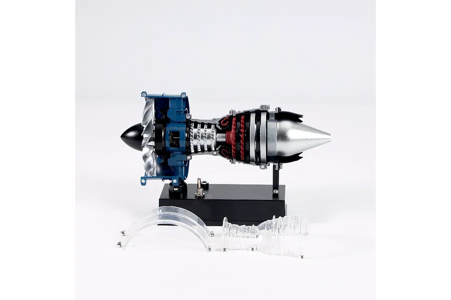 A Teching 1/20 scale metal turbofan engine model kit on a black display stand with two clear plastic casing pieces resting in front.