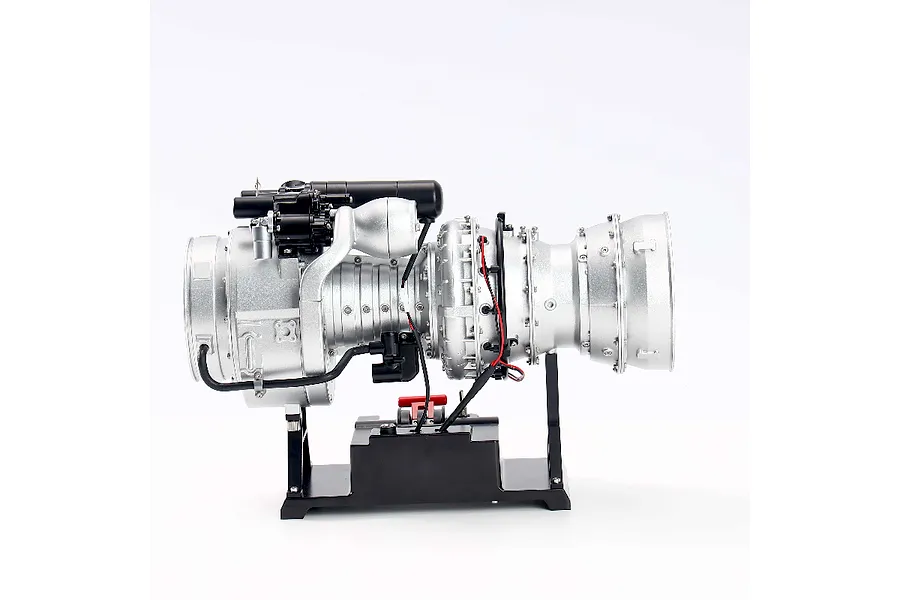 A side view of the Teching DM136 T-700 turboshaft engine metal model kit mounted on a black display stand against a white background.