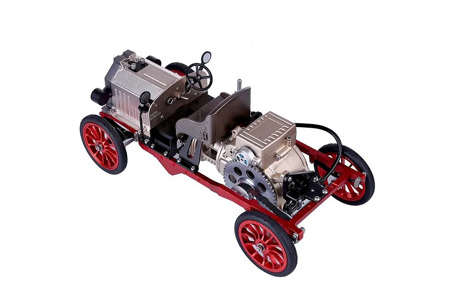 A high-angle studio shot of a Teching DM227 classic car metal model kit showing the chassis, engine, and red wheels.