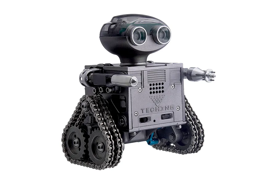 A Teching DM518 RC robot model kit featuring a grey metal body, tank-style treads, and a head with two large circular lens eyes.