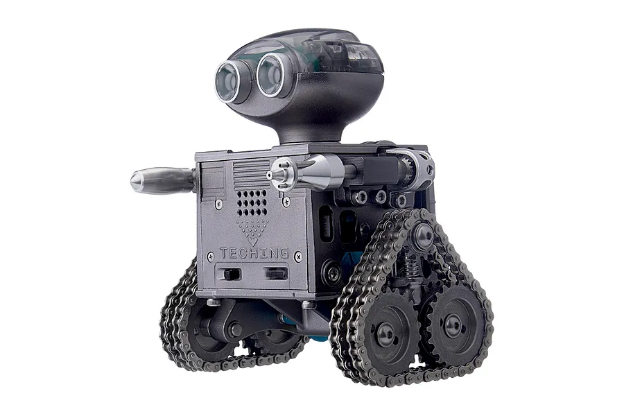 A Teching DM518 RC robot model kit featuring a metallic grey body, tank-style treads, and a rounded head with two circular eye-like lenses.