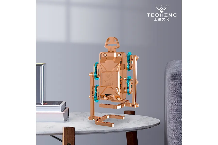 A metallic copper-coloured Teching DM520 walker robot model kit standing on a marble-topped table in a living room setting.