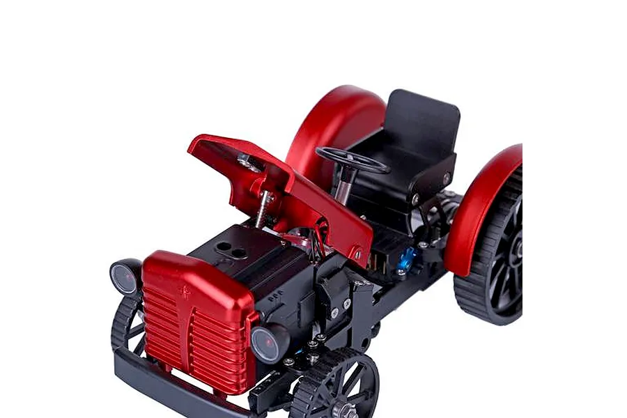 A high-angle view of a partially assembled red and black metal tractor model kit showing the engine bay and steering wheel.