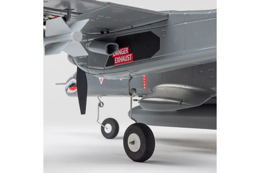 Close-up of the E-Flite Micro OV-10 Bronco RC plane showing the landing gear, propeller, and exhaust detail with a danger warning label.