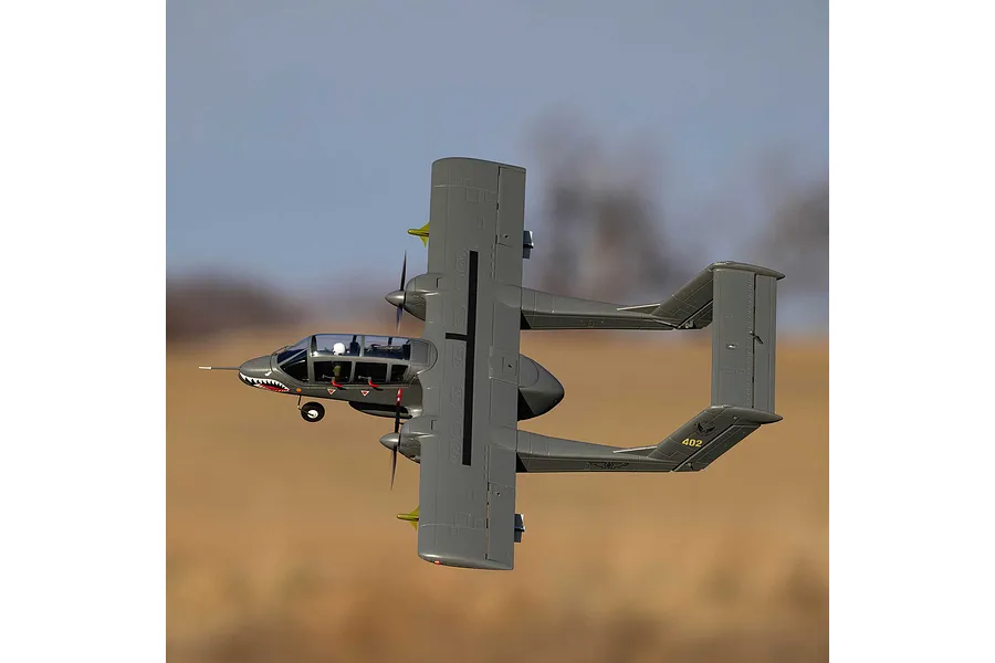 An E-Flite Micro OV-10 Bronco RC plane in flight against a blurred outdoor background.