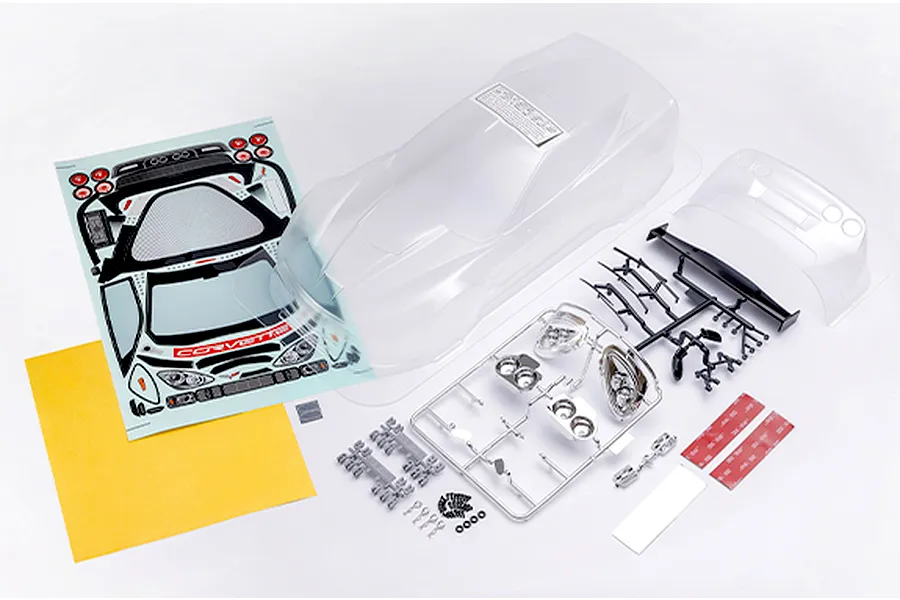 Killerbody Corvette GT2 unpainted clear RC body shell kit including decals, plastic parts trees, and mounting hardware on a white background.
