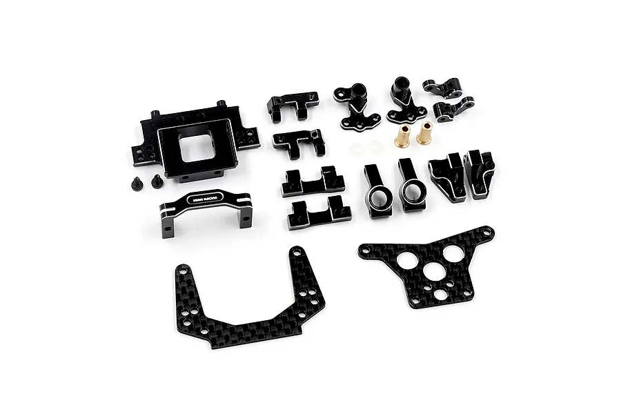 A collection of black anodized aluminium and carbon fiber RC car upgrade parts from Yeah Racing, laid out on a white background.