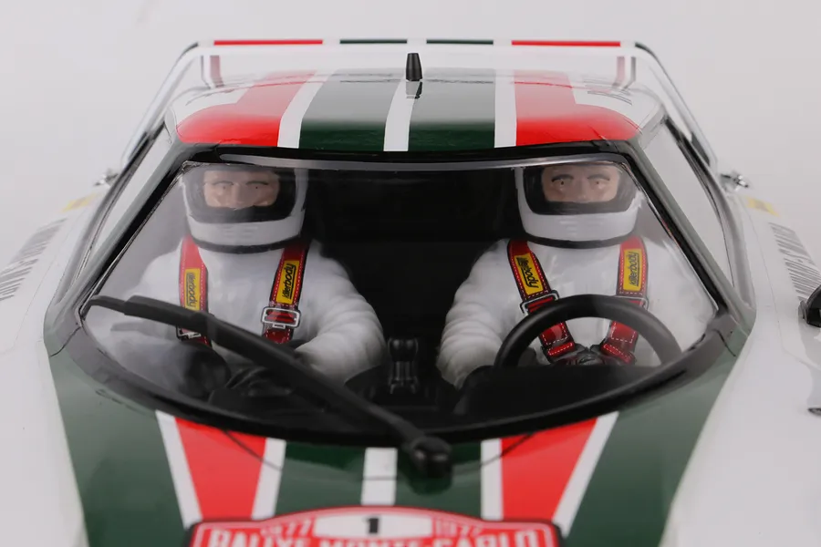 Close-up of a Killerbody Lancia Stratos RC car cockpit featuring two driver figures in racing suits and helmets.