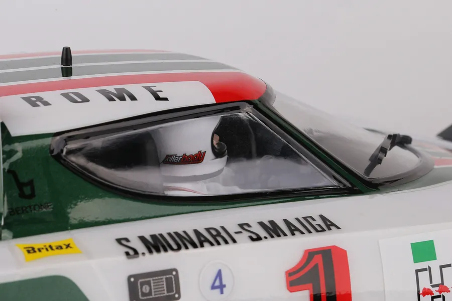 Close-up of a Killerbody Lancia Stratos RC car body showing the cockpit, driver figure, and race livery decals.