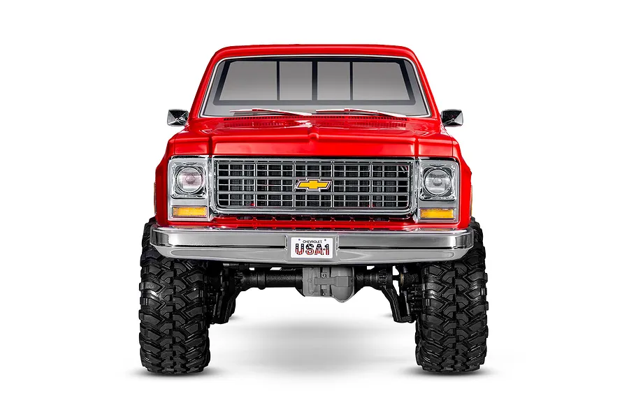 Front view of a red Traxxas TRX-4 1979 Chevrolet Cheyenne K10 RC rock crawler on a white background.