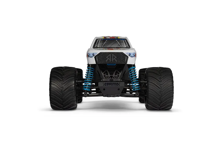 Front view of the ARRMA Freedom Flyer Grom 1/16 scale RC monster truck featuring a white body, blue coil-over shocks, and large black off-road tires.