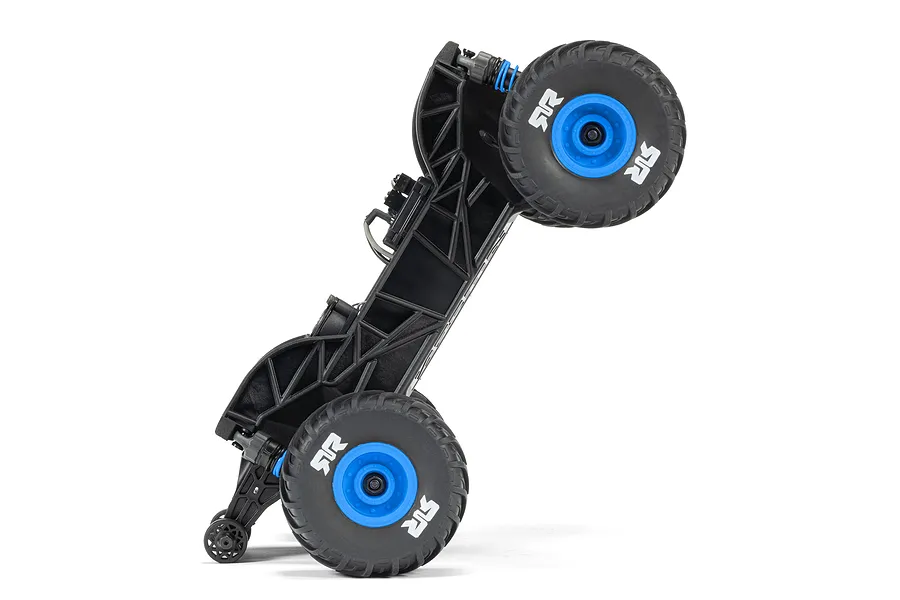 The chassis of an ARRMA Grom RC monster truck standing vertically on its rear wheels and wheelie bar against a white background.
