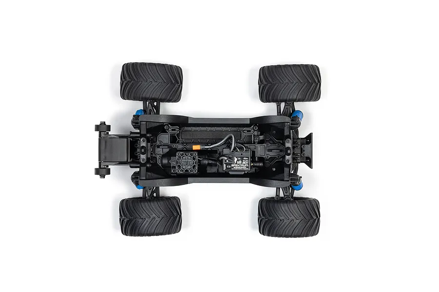 Top-down view of the ARRMA Grom RC monster truck chassis showing the motor, Spektrum electronics, and black rubber tires on a white background.