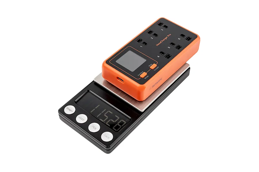 BetaFPV HexaCharger Pro 1S 6-port smart charger sitting on a digital scale showing a weight of 115.28 grams.