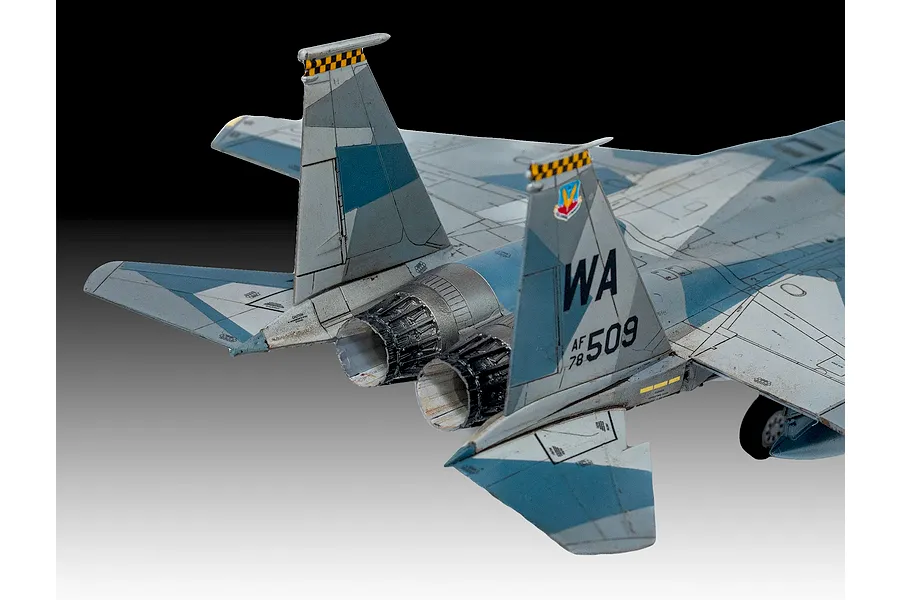 A detailed scale model of a Boeing F-15C Eagle fighter jet, showing the rear fuselage, twin engine nozzles, and vertical stabilizers with checkerboard markings.