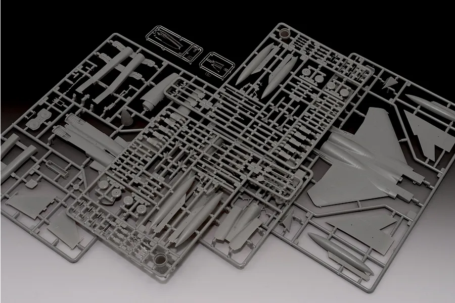 Grey plastic model kit sprues for a 1/72 scale Boeing F-15C Eagle fighter jet, showing various aircraft parts and clear canopy pieces.