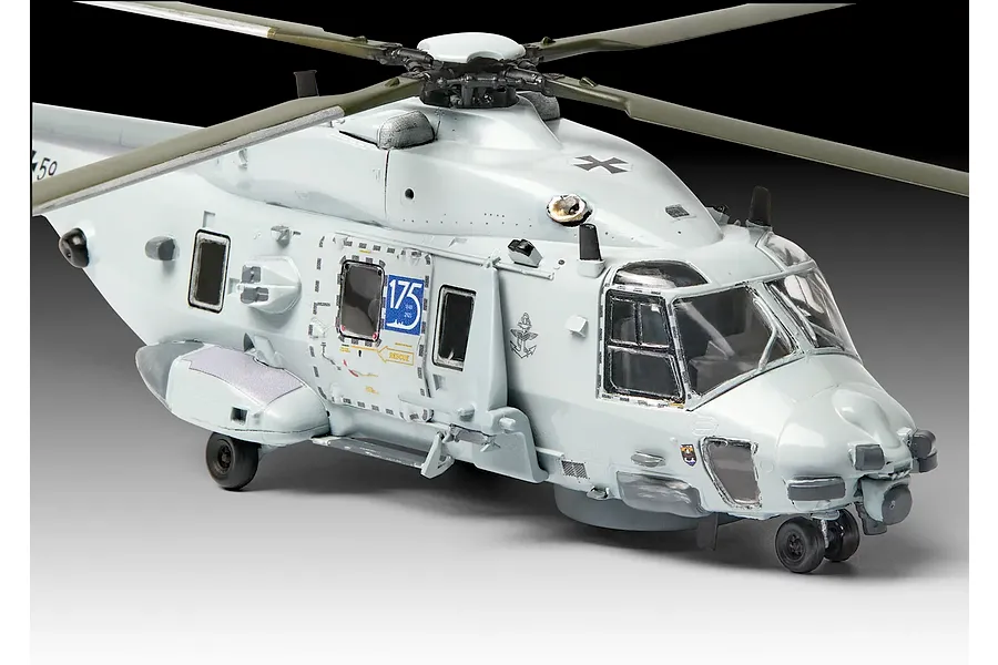 A completed 1/72 scale plastic model of a grey NH90 NFH Navy helicopter, featuring detailed decals and rotor blades, set against a neutral studio background.