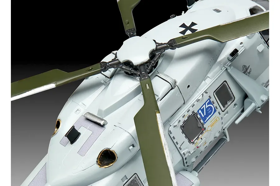 Close-up of a 1/72 scale plastic model NH90 helicopter showing the rotor assembly, fuselage, and German Navy markings.