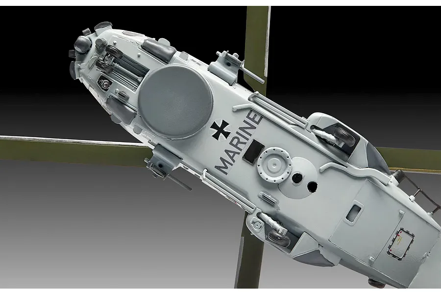 A bottom-up view of a 1/72 scale Revell NH90 NFH Navy helicopter model, showing the landing gear, radar dome, and German Marine markings.