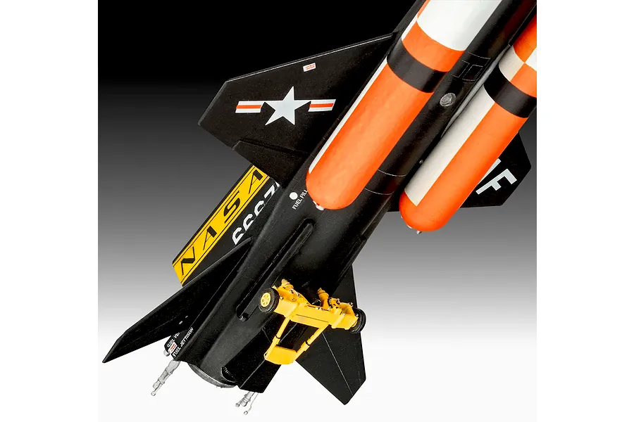 A close-up view of a scale model of the NASA X-15 rocket plane, showing the black fuselage, orange fuel tanks, and yellow landing gear.