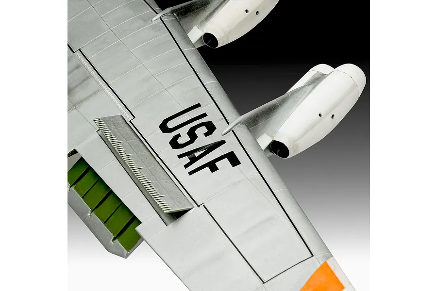 Close-up of a plastic model aircraft wing with USAF markings, white engine pods, and green flap details.