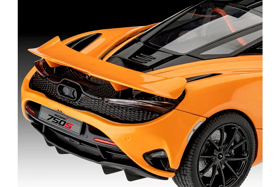 Close-up of the rear three-quarter view of an orange McLaren 750S scale model car, showing the spoiler, taillights, and rear diffuser.