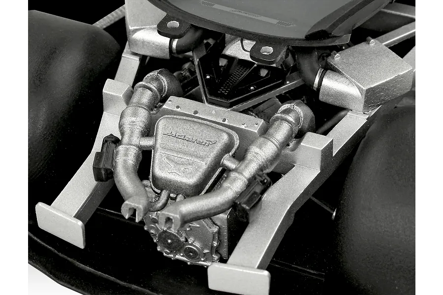Close-up of the detailed engine bay of a 1/24 scale McLaren 750S model car kit, showing the silver engine block and intake manifold.