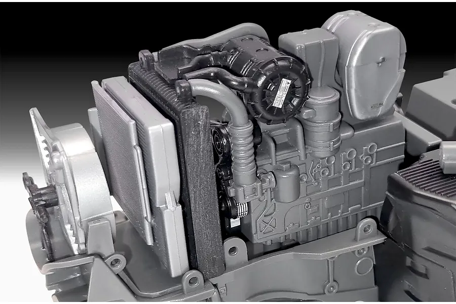 Close-up of the unpainted plastic engine block and radiator assembly for a Revell 1/24 scale Fendt 728 Vario tractor model kit.