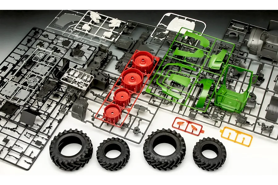 Plastic model kit sprues and rubber tires for a Revell Fendt 728 Vario tractor model, laid out on a surface.