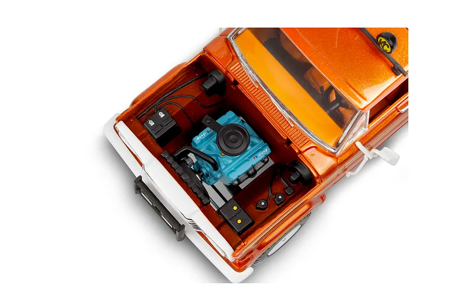 High-angle close-up of a 1/24 scale orange Jeep J-10 model truck with the hood open, revealing a detailed blue engine block.