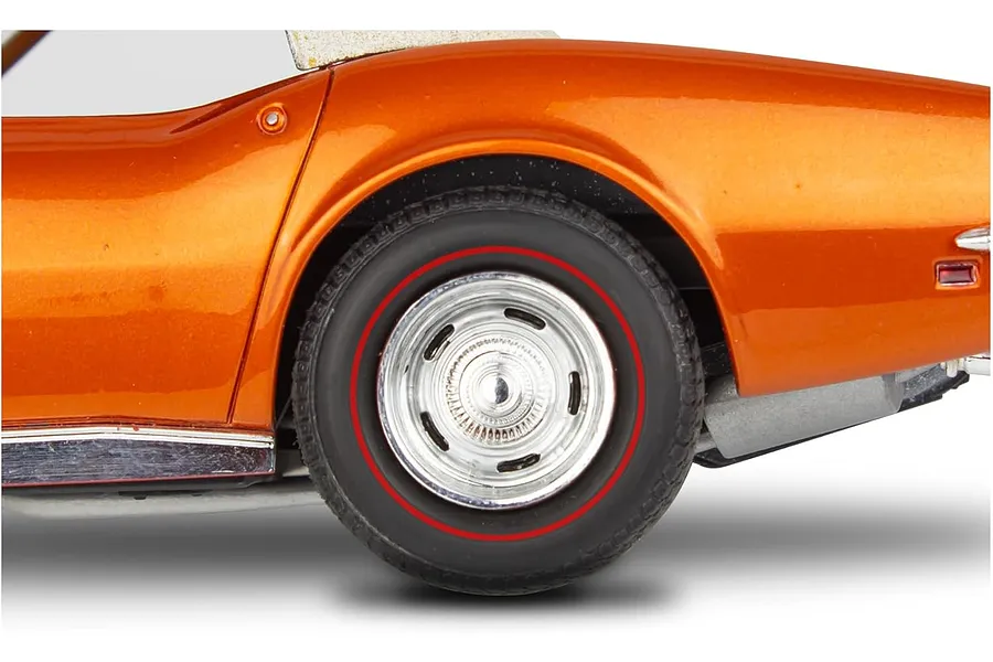 Close-up of the rear wheel and fender of an orange 1/25 scale model Corvette with a red-line tire and chrome rally wheel.