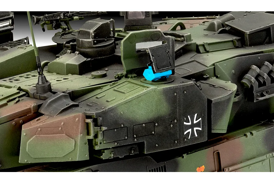 Close-up of the turret section of a 1/35 scale Leopard 2A7A1 model tank featuring camouflage paint and a German Iron Cross decal.